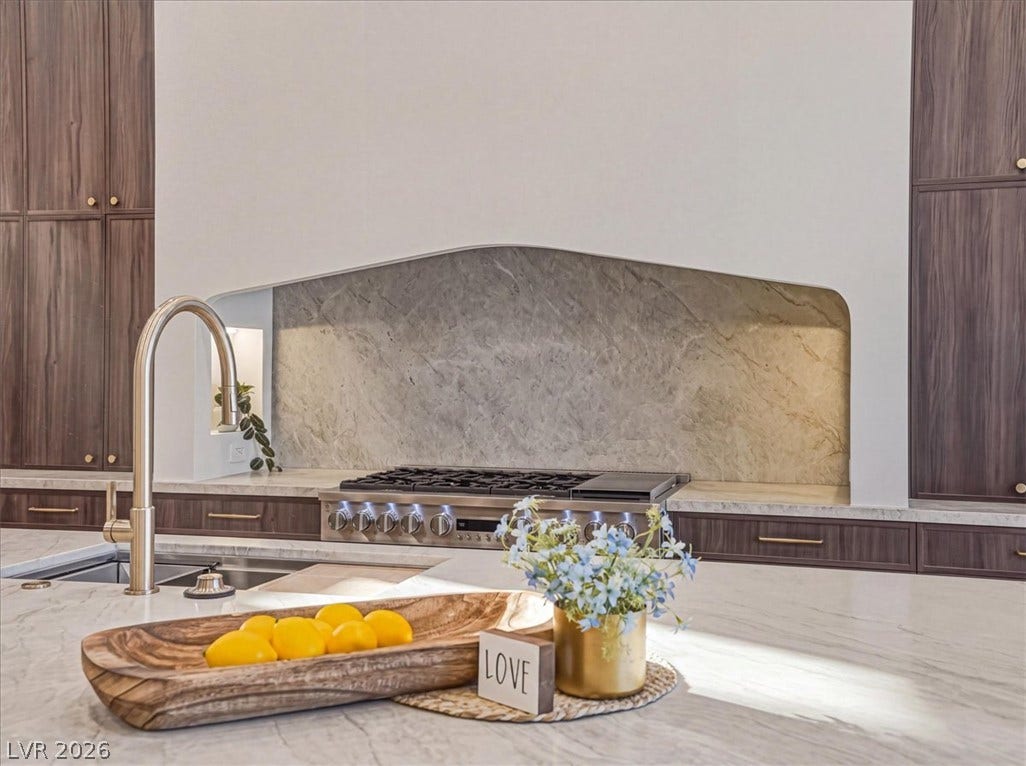 3 Isleworth Drive, Henderson, NV 89052 Marble countertops and a modern range highlight this contemporary kitchen's appeal.