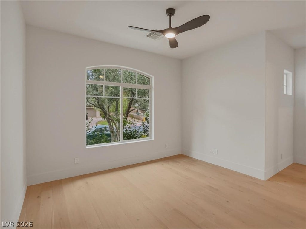 3 Isleworth Drive, Henderson, NV 89052 A graceful arched window overlooks the mature trees, bringing natural light into this quiet room.