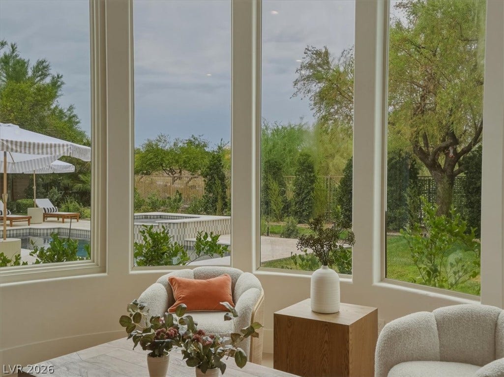 3 Isleworth Drive, Henderson, NV 89052 A spacious room offers an expansive view of the private yard, sparkling pool, and mature trees.
