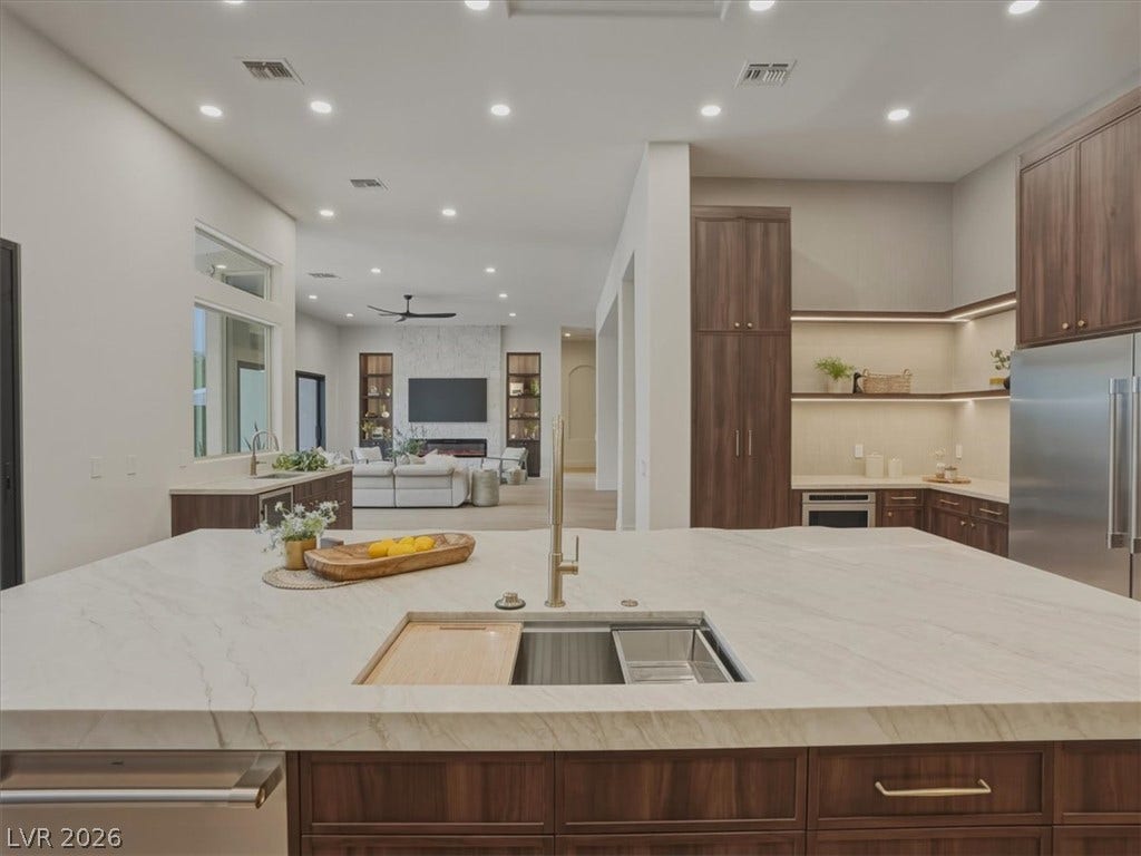 3 Isleworth Drive, Henderson, NV 89052 An open-concept kitchen features a large island and ample cabinetry, flowing seamlessly into the inviting living area.