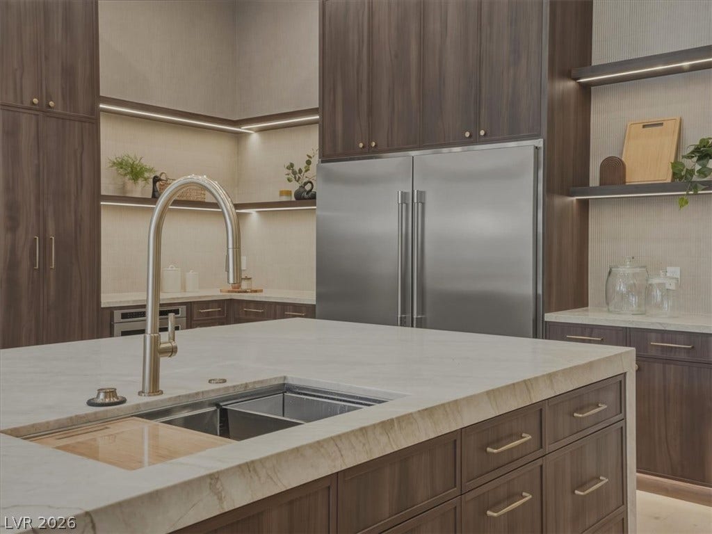 3 Isleworth Drive, Henderson, NV 89052 Culinary excellence awaits in this kitchen featuring abundant cabinetry and sleek stainless-steel appliances.