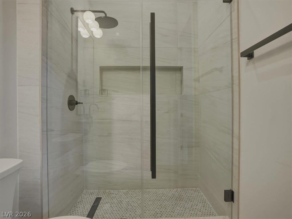 3 Isleworth Drive, Henderson, NV 89052 A sleek, contemporary shower enclosure features clean lines and a rain showerhead, providing a serene bathing experience.