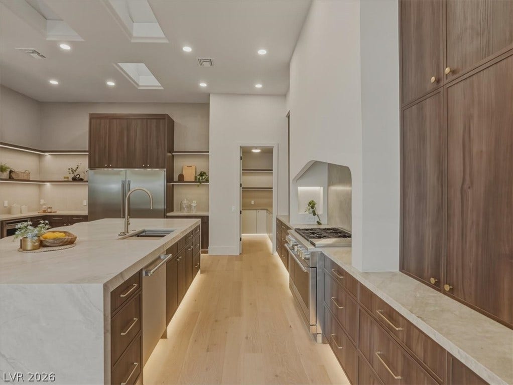3 Isleworth Drive, Henderson, NV 89052 An inviting kitchen provides a vast center island and premium stainless steel appliances, all illuminated by recessed lighting and skylights.