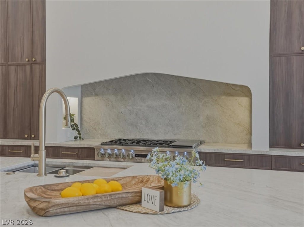 3 Isleworth Drive, Henderson, NV 89052 A well-appointed kitchen features a sleek gas range, a modern faucet, and rich cabinetry.