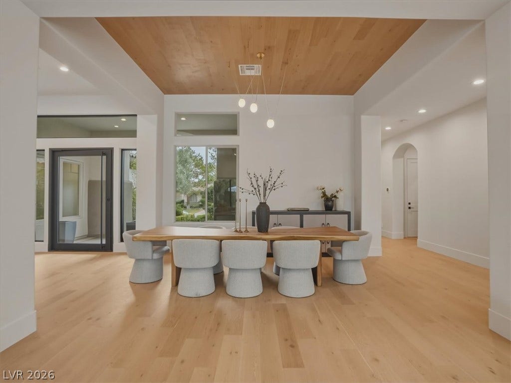 3 Isleworth Drive, Henderson, NV 89052 A spacious dining area showcases light hardwood flooring, abundant natural light, and a striking wood-paneled ceiling feature.