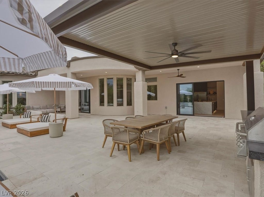 3 Isleworth Drive, Henderson, NV 89052 An inviting outdoor living space features a dining area, comfortable lounge seating, and an integrated grill under a shaded patio.