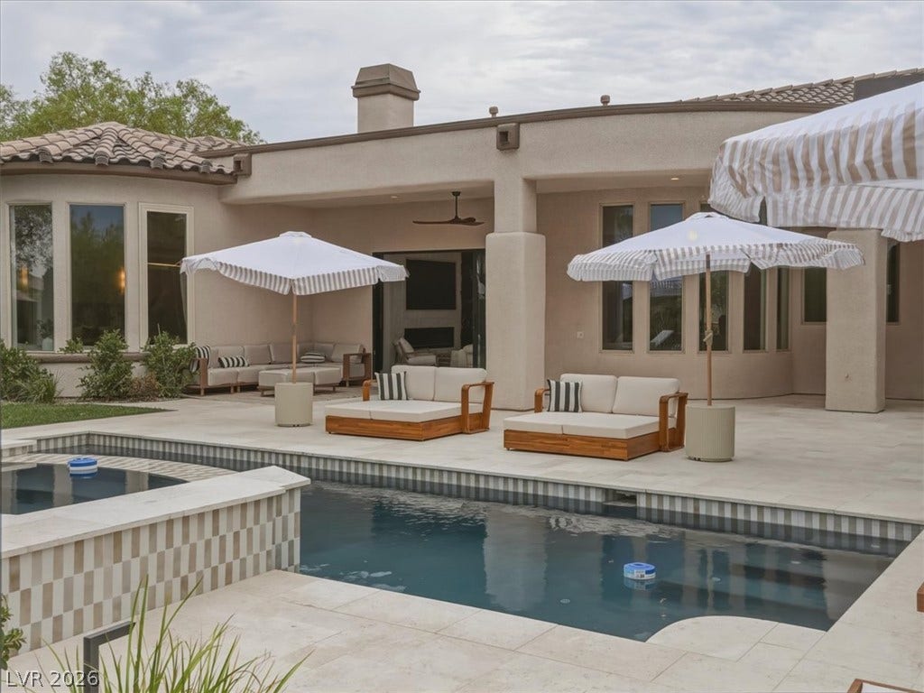 3 Isleworth Drive, Henderson, NV 89052 An inviting backyard oasis offers a sparkling pool with a connected spa, surrounded by ample patio space for relaxation and entertaining.