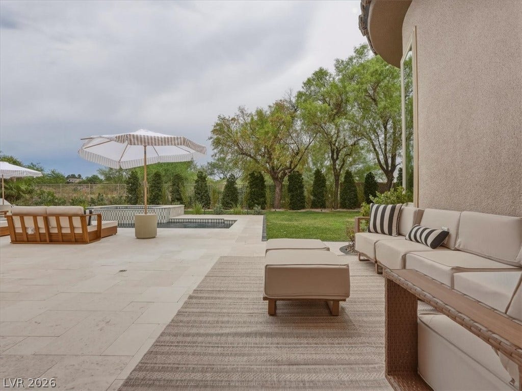 3 Isleworth Drive, Henderson, NV 89052 A spacious backyard oasis features a glistening pool, verdant lawn, and an inviting patio perfect for leisure.
