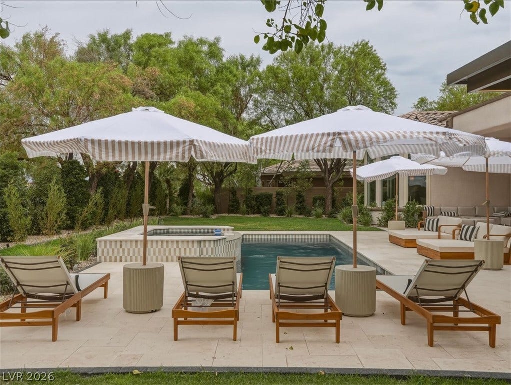 3 Isleworth Drive, Henderson, NV 89052 An inviting backyard oasis offers a sparkling pool with an integrated spa, bordered by lush landscaping.
