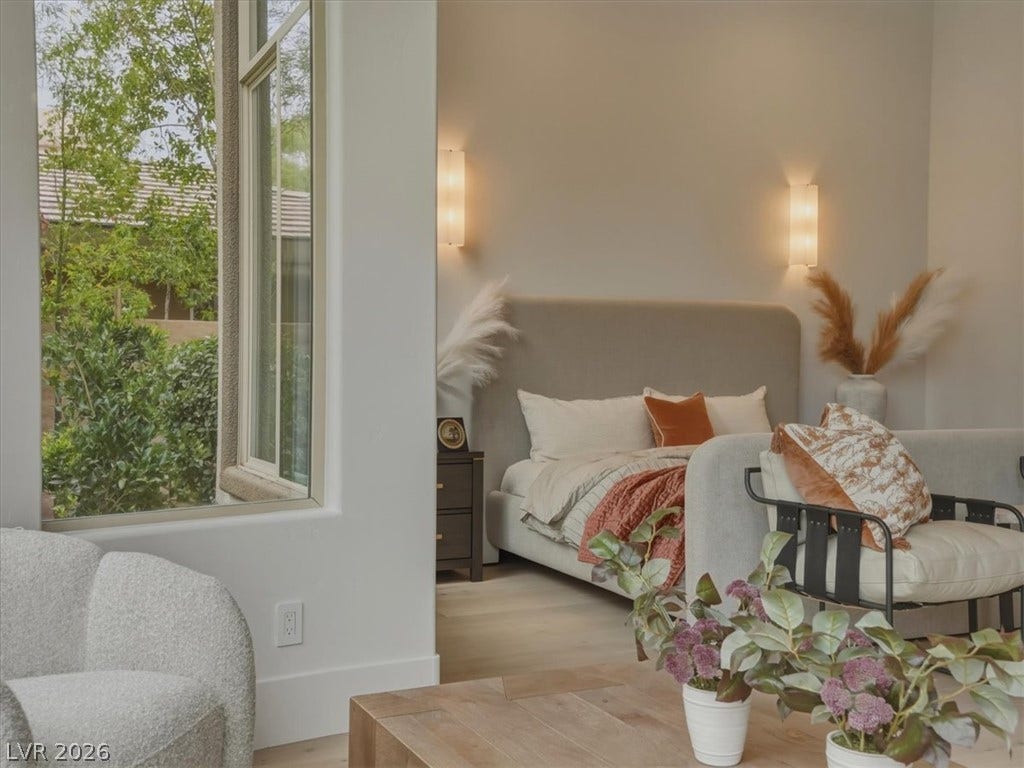 3 Isleworth Drive, Henderson, NV 89052 Sun-filled bedroom featuring wide windows that offer green exterior views, creating a serene and airy atmosphere.