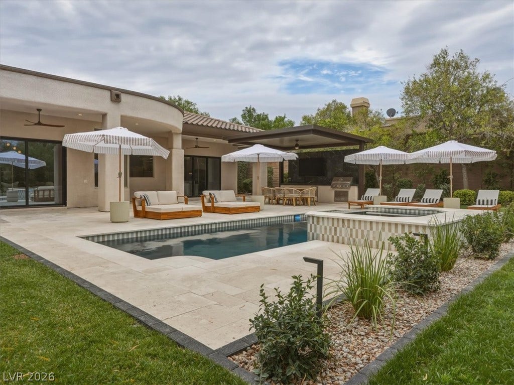 3 Isleworth Drive, Henderson, NV 89052 An inviting outdoor oasis features a refreshing pool and spa, alongside an elegant outdoor kitchen for memorable gatherings.