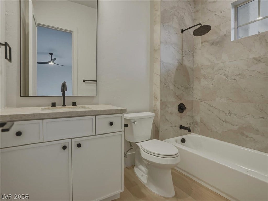 3 Isleworth Drive, Henderson, NV 89052 Modern bathroom featuring a single vanity, a sleek black faucet, and a shower-tub combination with elegant tile surround.