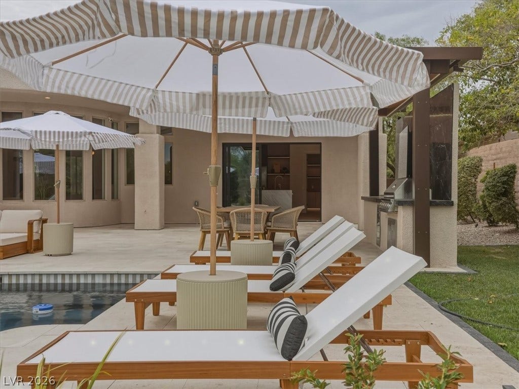 3 Isleworth Drive, Henderson, NV 89052 An inviting backyard oasis offers a sparkling pool and a sophisticated outdoor kitchen for seamless entertaining.