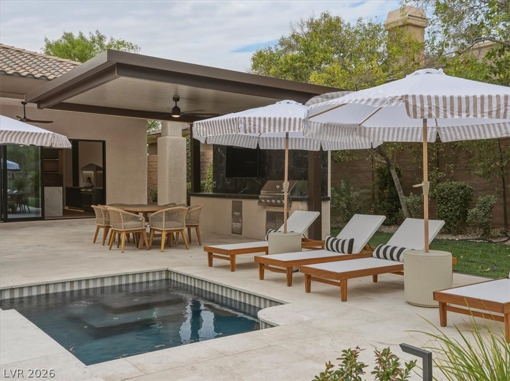 3 Isleworth Drive, Henderson, NV 89052 An inviting outdoor oasis awaits with a sparkling pool, shaded lounge areas, and a full outdoor kitchen.