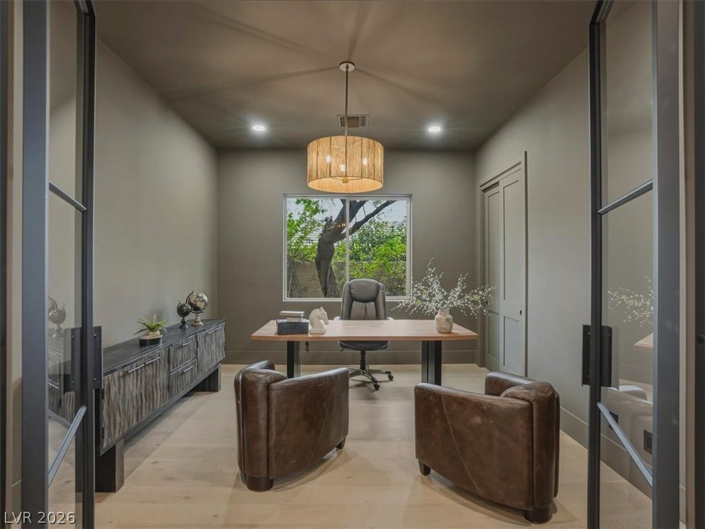 3 Isleworth Drive, Henderson, NV 89052 A well-lit study space with light wood flooring and a view of lush greenery through the window.