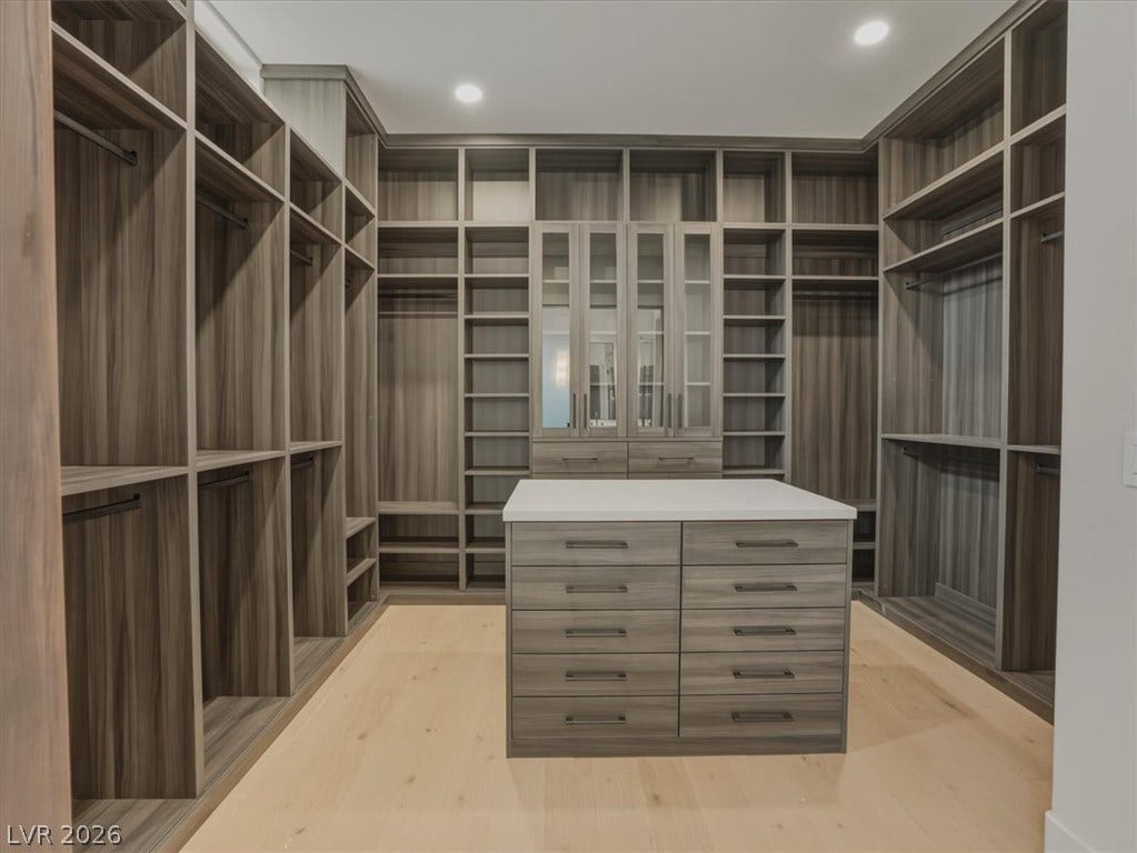 3 Isleworth Drive, Henderson, NV 89052 Ample storage solutions abound in this well-appointed walk-in closet, featuring a central island with integrated drawers.