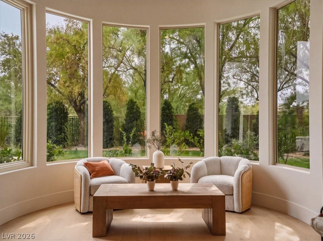 3 Isleworth Drive, Henderson, NV 89052 Natural light floods this inviting sitting room, offering peaceful garden views through expansive windows.