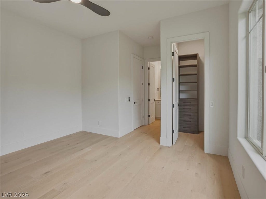 3 Isleworth Drive, Henderson, NV 89052 Bright, airy bedroom featuring natural wood flooring and a convenient walk-in closet.