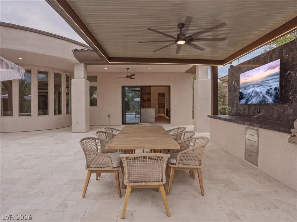 3 Isleworth Drive, Henderson, NV 89052 An inviting outdoor dining area features a large table and an outdoor kitchen with an entertainment center.