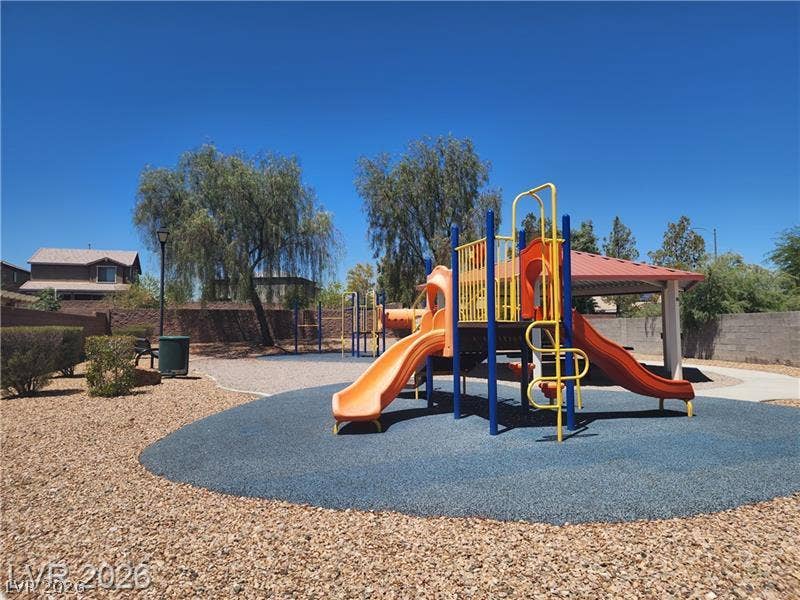 1705 Ronzard Avenue, North Las Vegas, NV 89032 An outdoor neighborhood playground structure features multiple slides set beneath a clear blue sky.