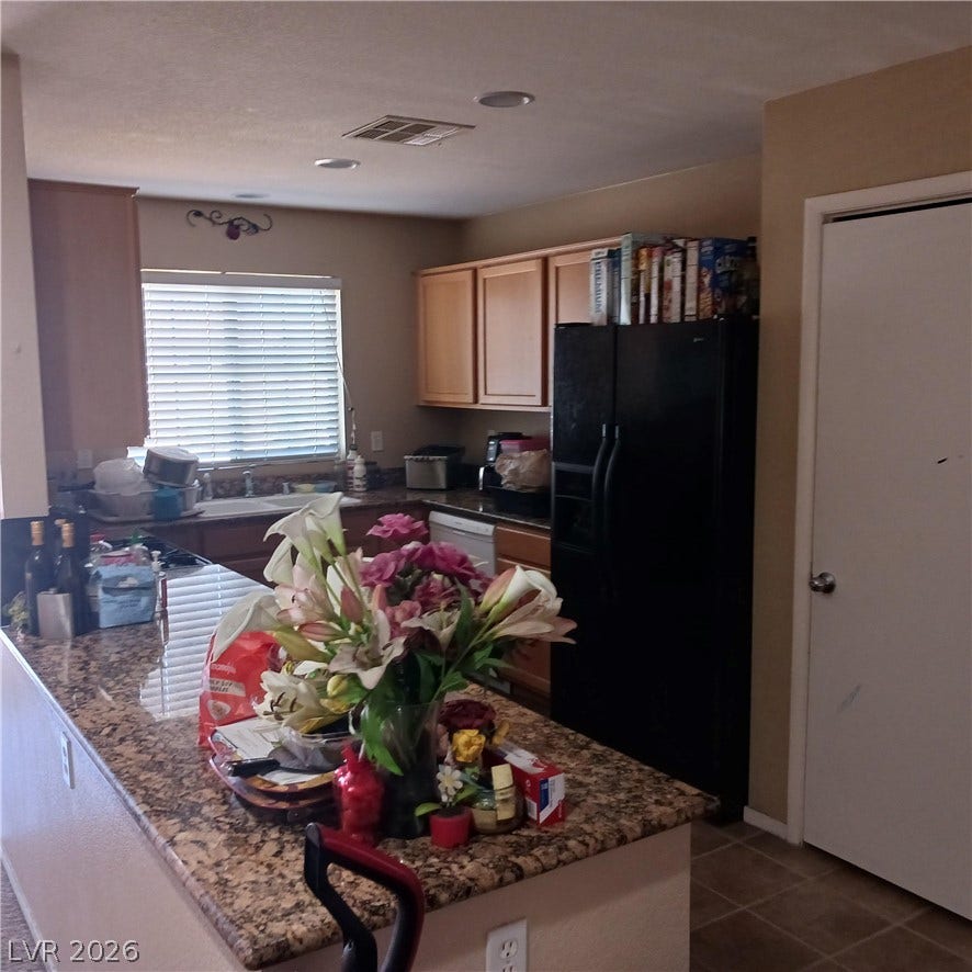 1705 Ronzard Avenue, North Las Vegas, NV 89032 Polished granite countertops accent this functional kitchen space complete with an island.