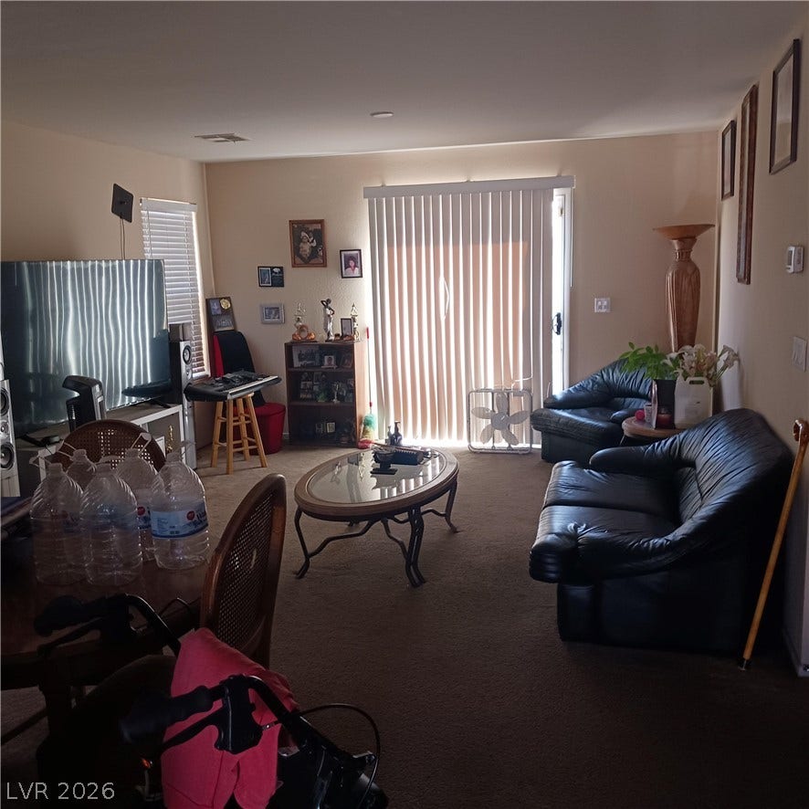 1705 Ronzard Avenue, North Las Vegas, NV 89032 Sliding glass doors open from the carpeted living area to the outdoors.