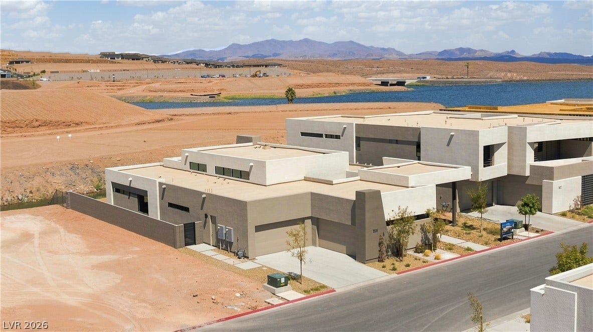 Sleek contemporary architecture blends into the desert landscape overlooking tranquil water views.