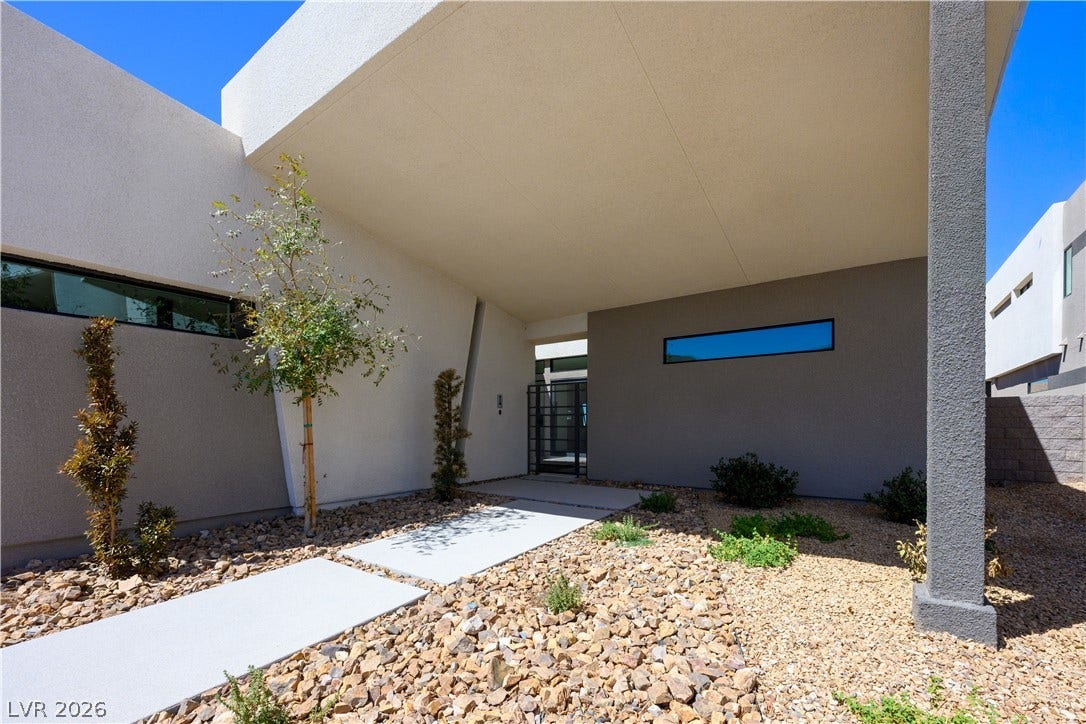 Bold geometric lines and xeriscaped pathways create a striking modern entry experience.