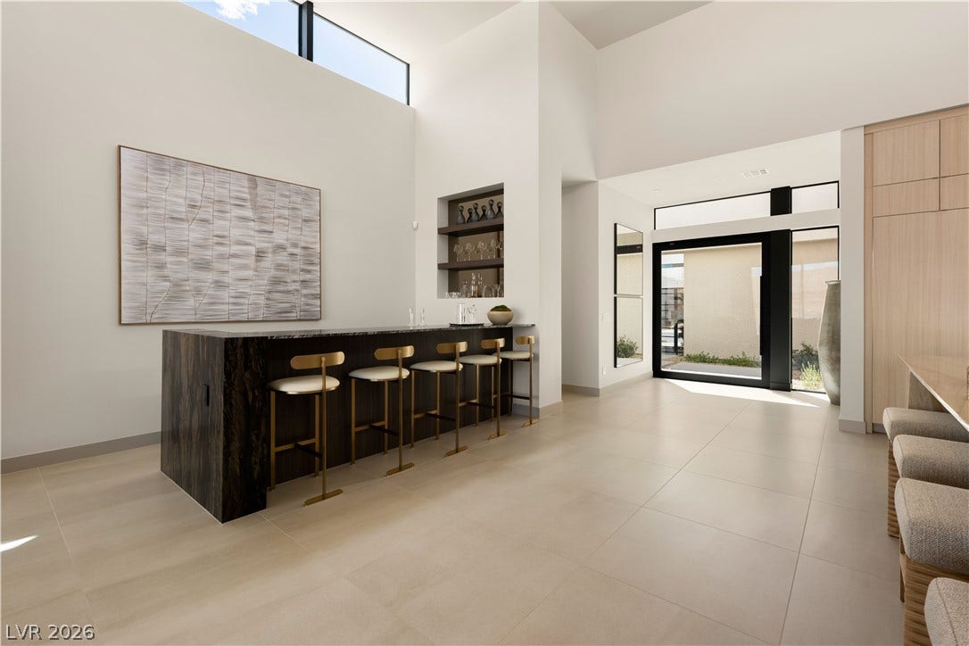 Gleaming tile floors and soaring ceilings frame this contemporary home entrance and wet bar area.