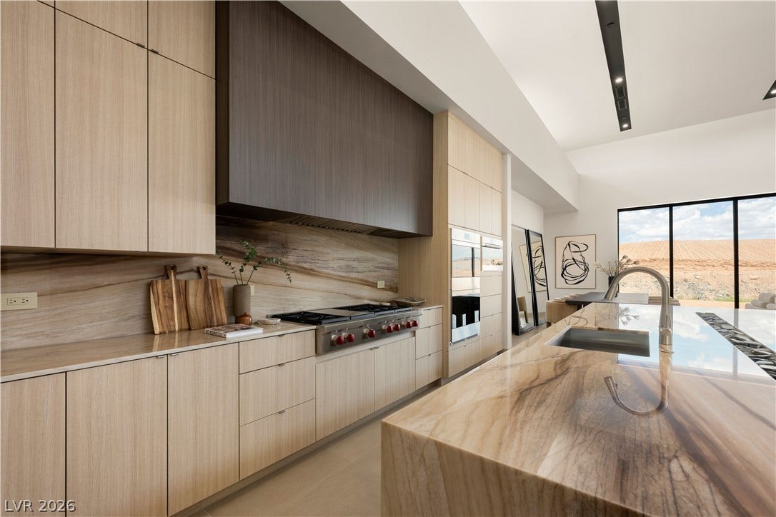 Premium stone countertops and modern flat-panel cabinetry define this culinary space.