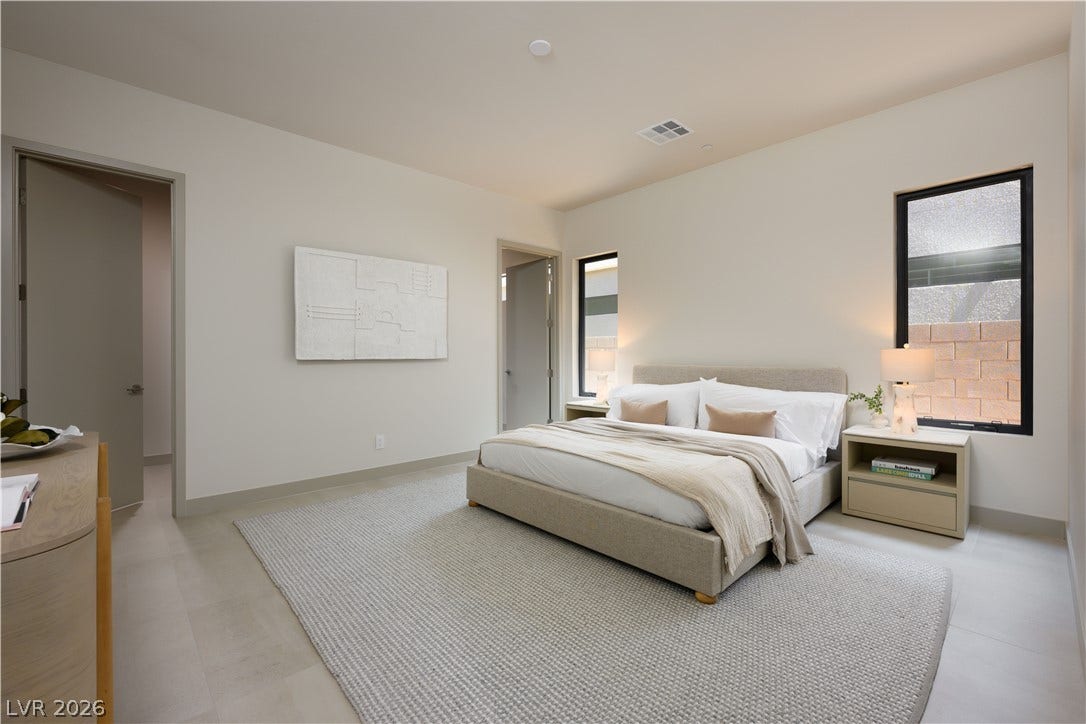 Clean lines and a minimalist aesthetic define this serene bedroom space with neutral flooring.