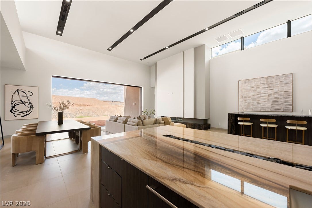 Gleaming stone countertops and clean architectural lines define this expansive, modern open-concept space.