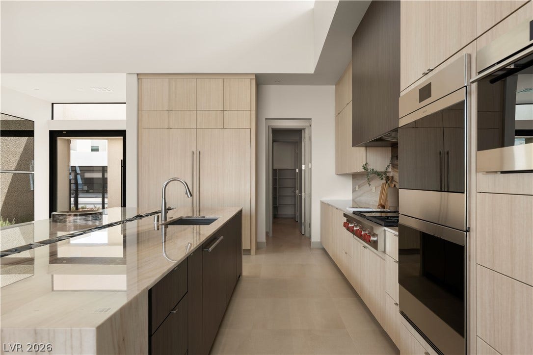 Minimalist design elements define this culinary space equipped with premium appliances and stone countertops.