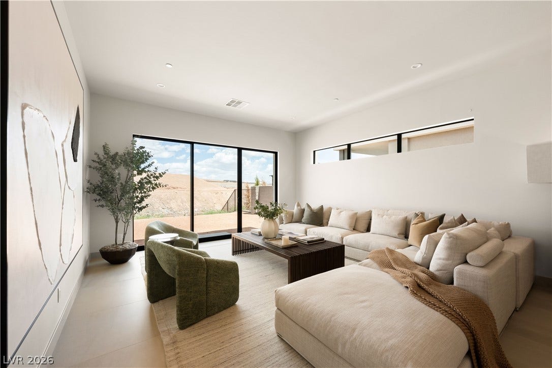 Recessed lighting, smooth plaster walls, and large glass doors create a serene, minimalist environment.