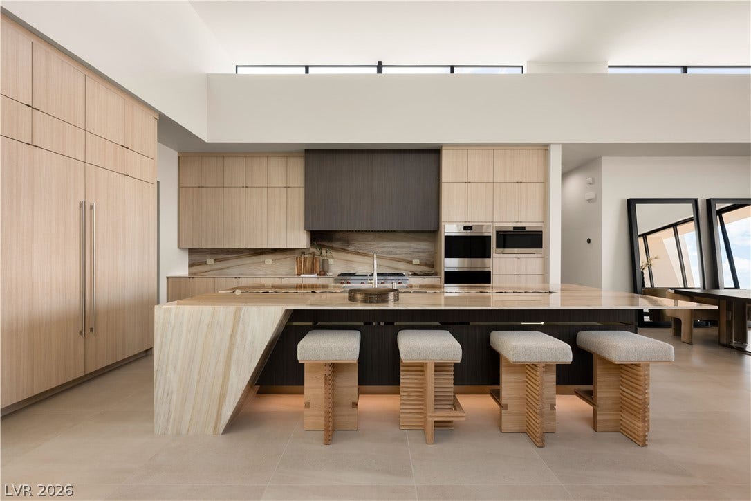 High ceilings and a massive central island define this architectural kitchen space.