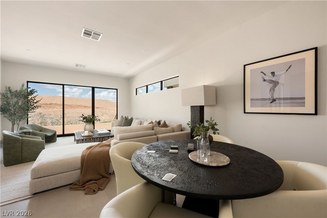 Clean lines and vast sliding doors frame distant natural views from this modern open-plan living space.