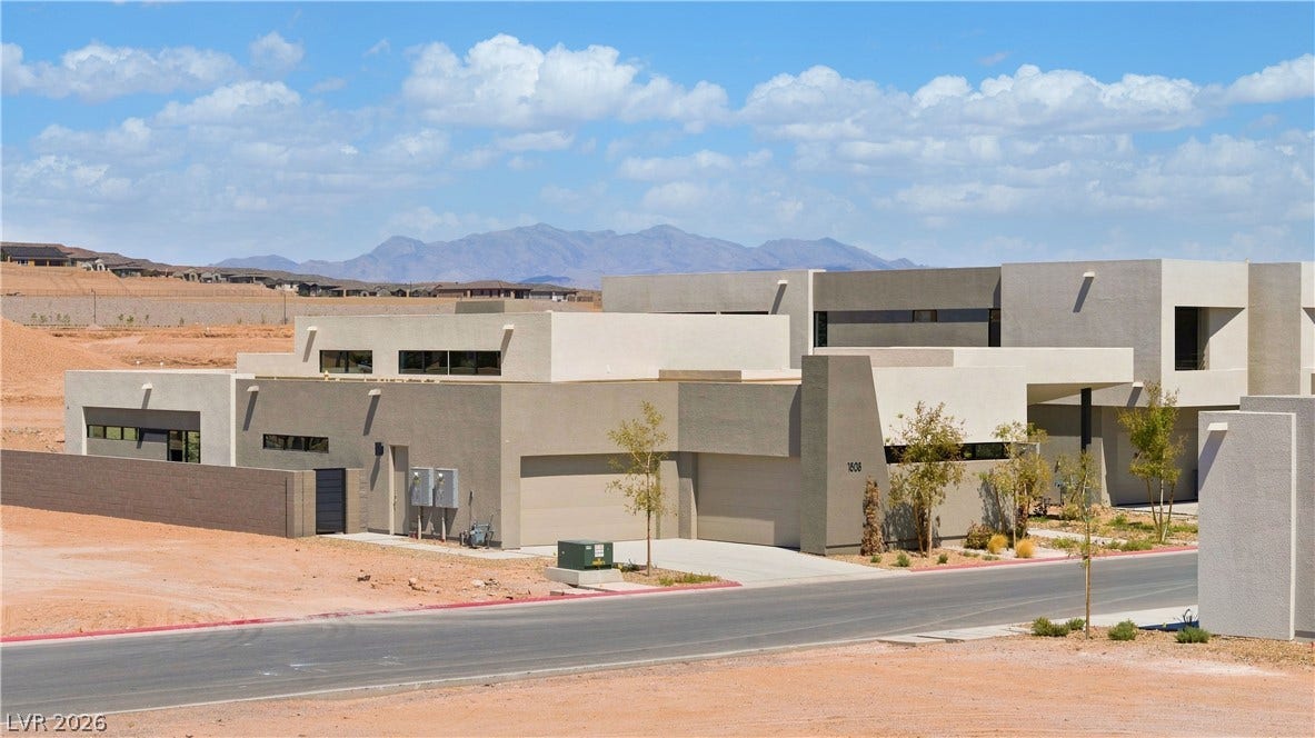 Bold contemporary architecture stands out against a dramatic desert mountain backdrop.