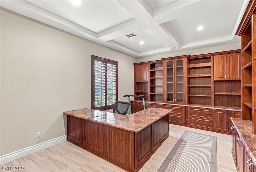 1372 Enchanted River Drive, Henderson, NV 89012 Rich wood built-ins and a detailed coffered ceiling define this functional office space.