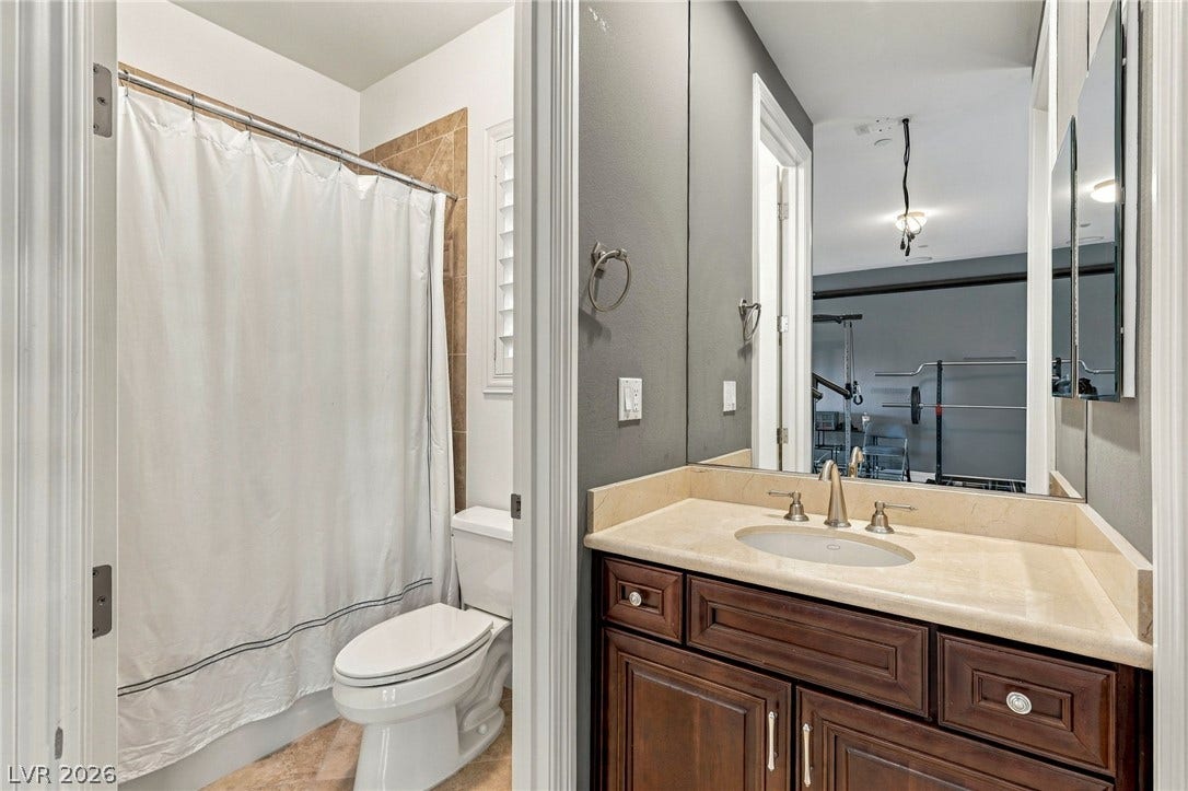 1372 Enchanted River Drive, Henderson, NV 89012 A classic vanity with a stone countertop sits adjacent to a neat bathroom area.