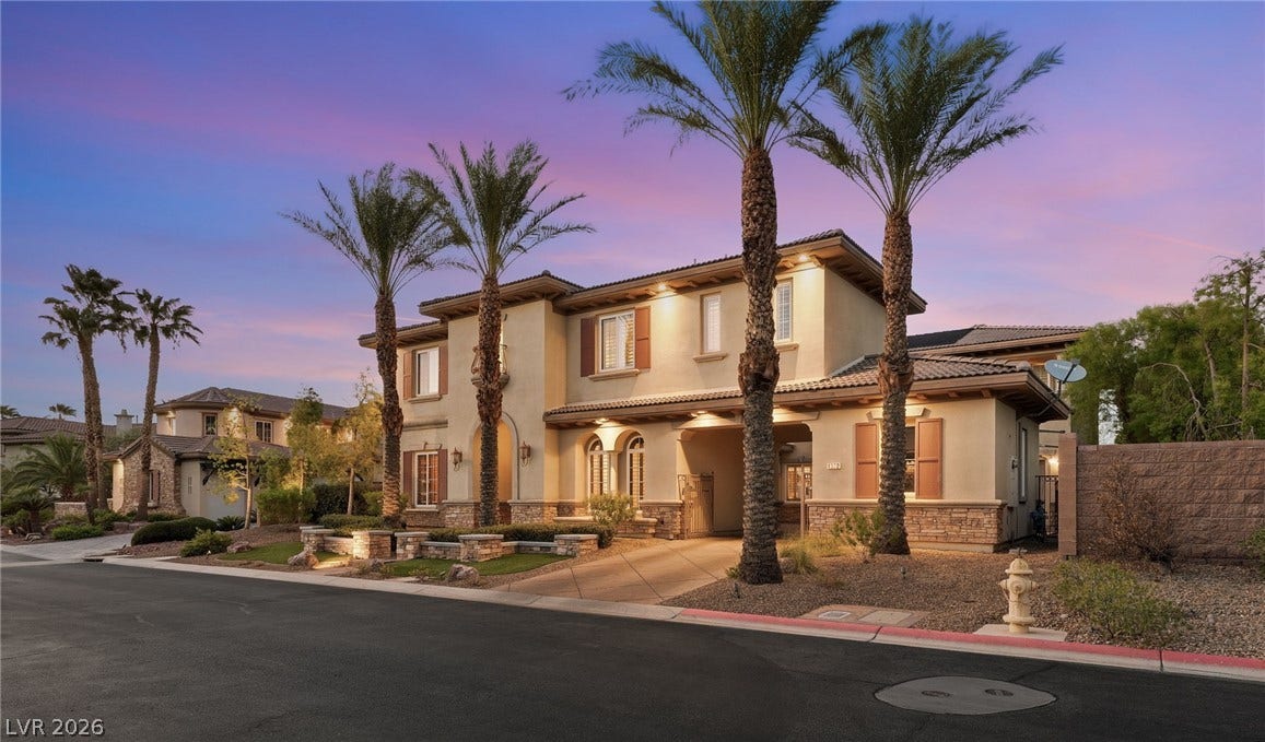 1372 Enchanted River Drive, Henderson, NV 89012 Towering palm trees frame the elegant exterior architecture of this multi-level stucco home.