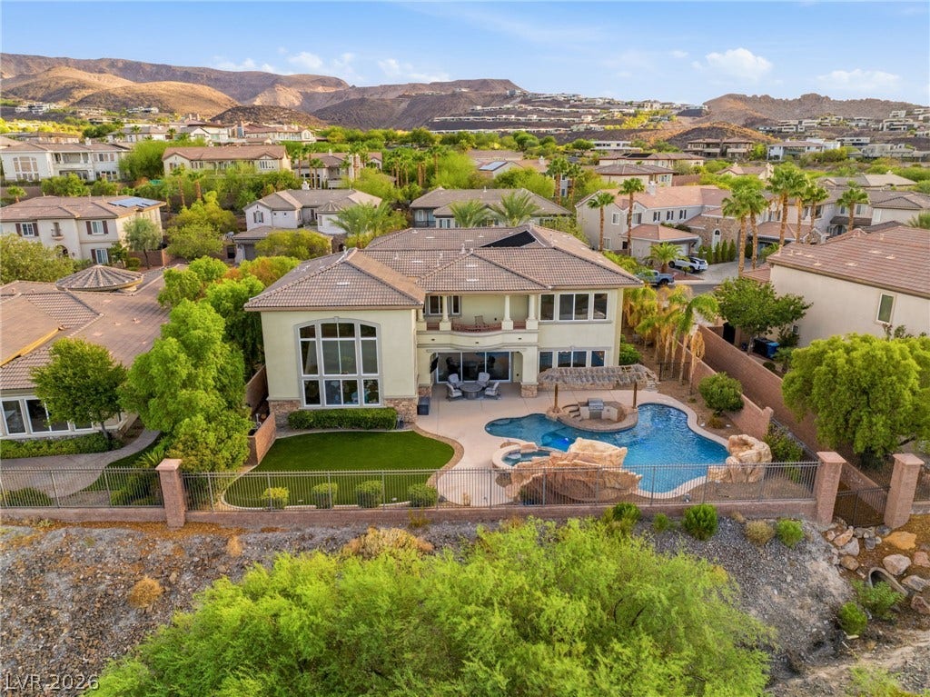 1372 Enchanted River Drive, Henderson, NV 89012 An inviting backyard oasis features a custom rock pool backed by scenic mountain vistas.