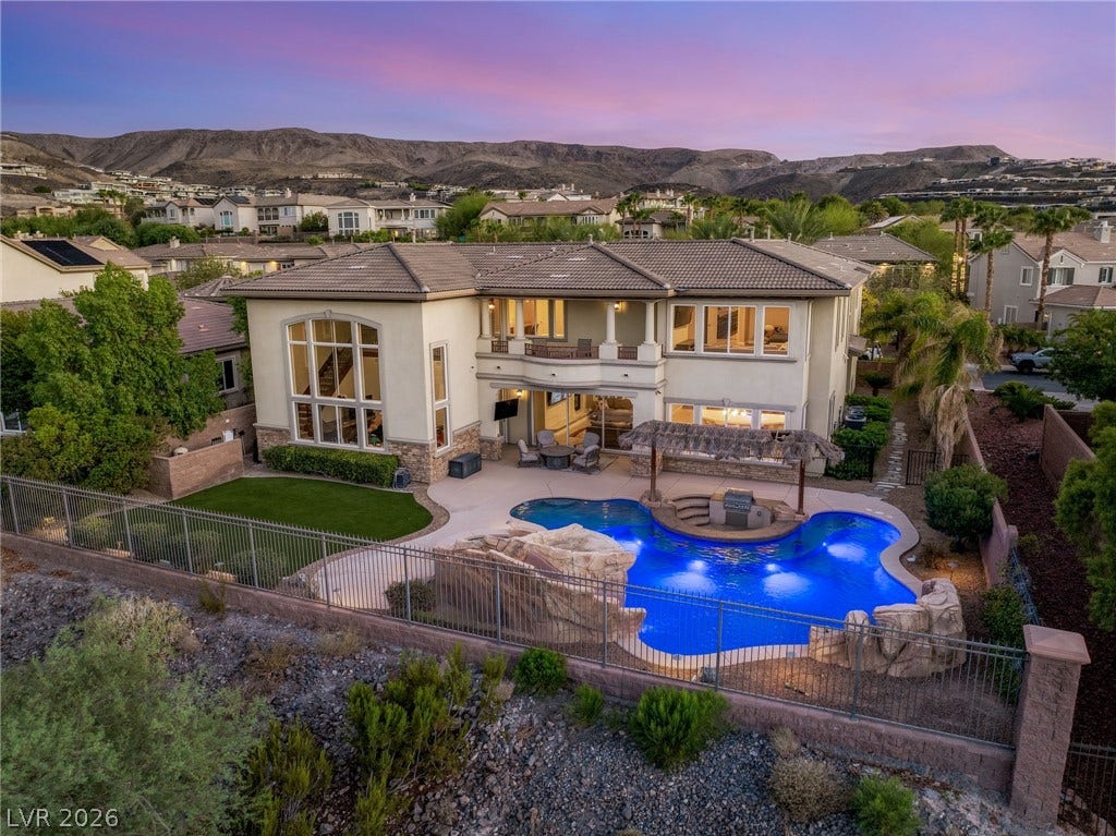 1372 Enchanted River Drive, Henderson, NV 89012 An inviting backyard oasis features a custom swimming pool set against a majestic mountain backdrop.