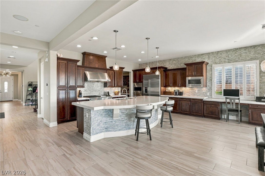 1372 Enchanted River Drive, Henderson, NV 89012 Gleaming tiled floors sweep through this expansive cooking space featuring a curved center island.