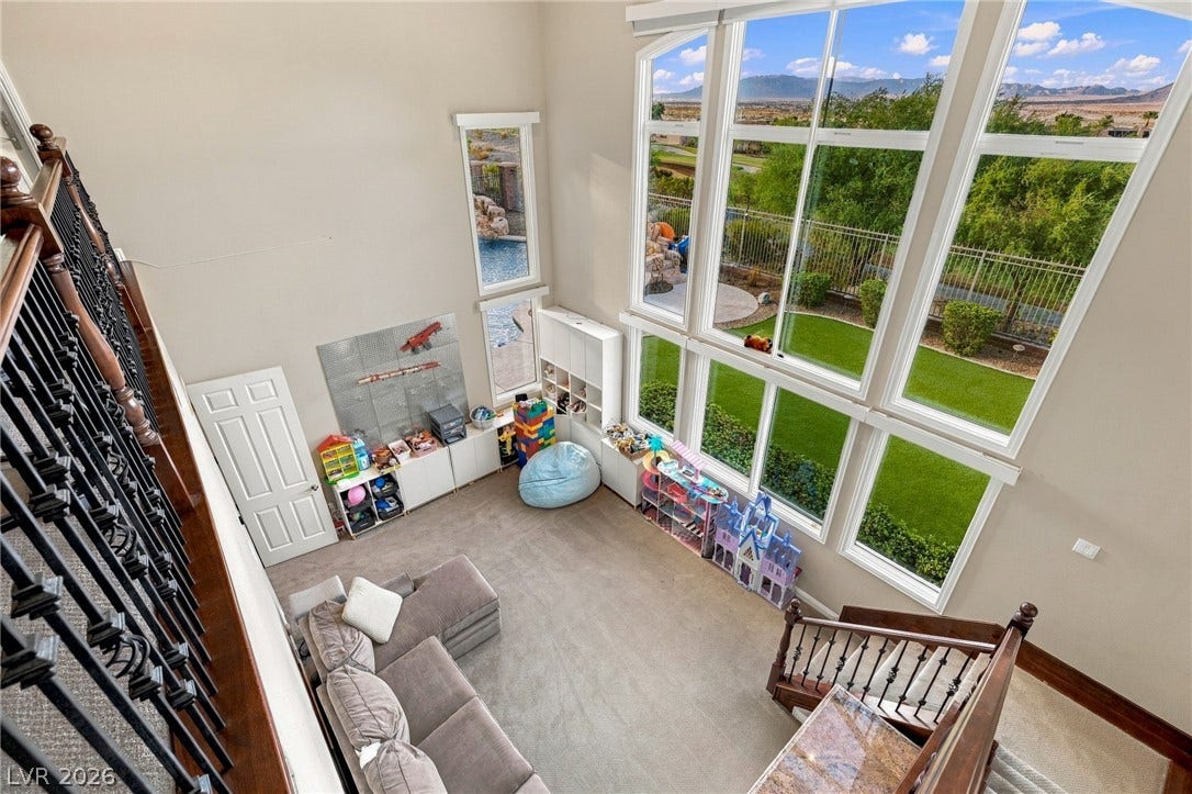 1372 Enchanted River Drive, Henderson, NV 89012 Towering windows frame distant mountain views from this light-filled room with high ceilings.