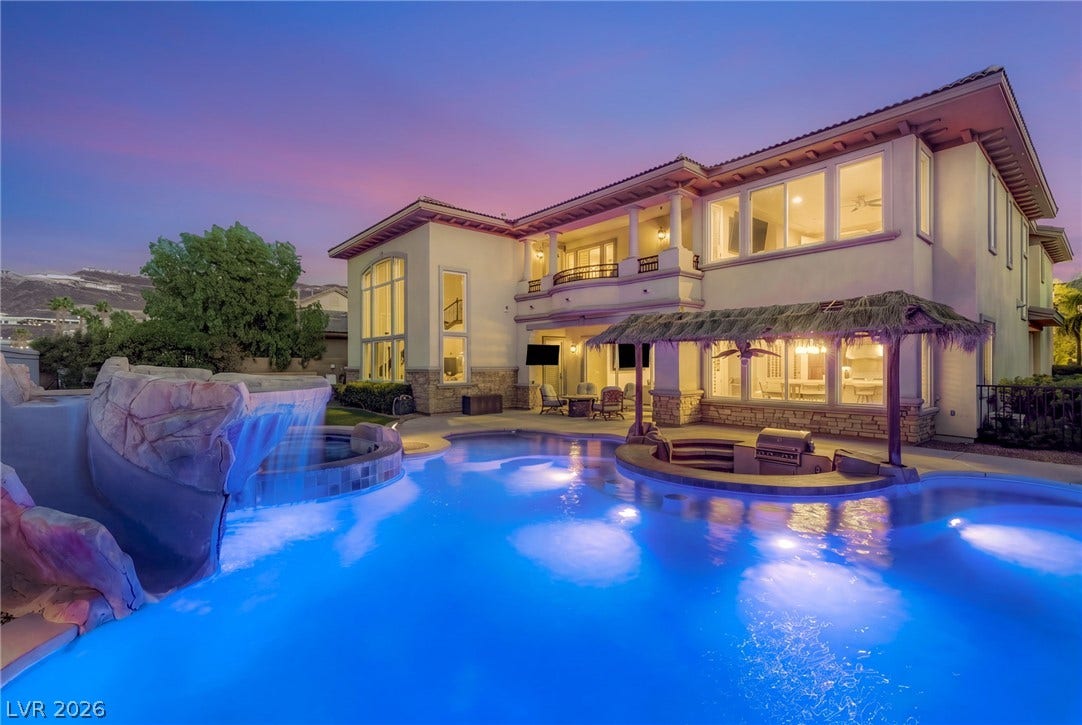 1372 Enchanted River Drive, Henderson, NV 89012 An illuminated custom swimming pool with a waterfall anchors this luxurious Mediterranean back yard.