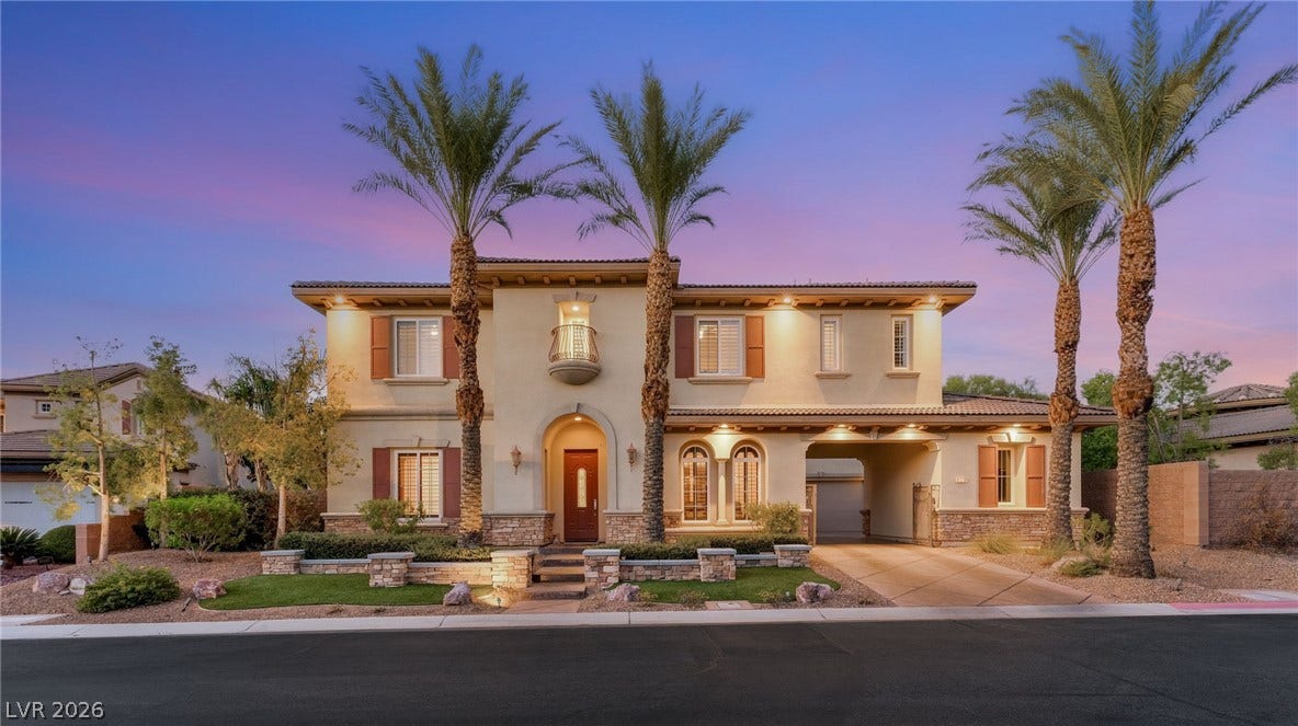 1372 Enchanted River Drive, Henderson, NV 89012 Palm trees frame this elegant two-story estate with stone accents and a gated portico.