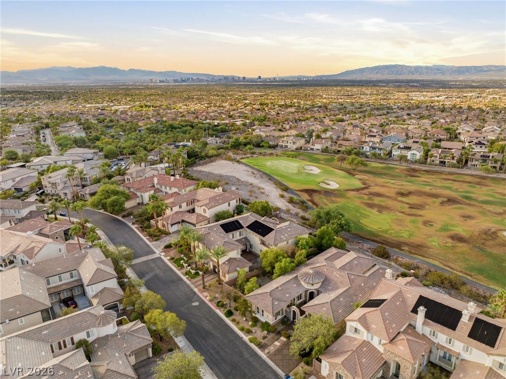 1372 Enchanted River Drive, Henderson, NV 89012 An aerial perspective showcases a neighborhood bordering a green golf course under clear desert skies.