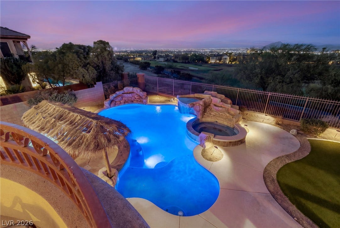 1372 Enchanted River Drive, Henderson, NV 89012 A resort-style pool and spa overlook glittering city lights under a vibrant twilight sky.