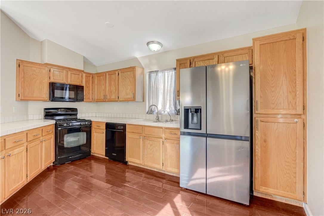 5239 Ferrell Mountain Court, North Las Vegas, NV 89031 Rich hardwood flooring pairs with classic oak cabinetry in this functional cooking space.