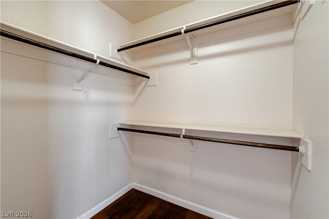 5239 Ferrell Mountain Court, North Las Vegas, NV 89031 Organized storage abounds in a dedicated walk-in closet featuring built-in shelving and rich wood flooring.